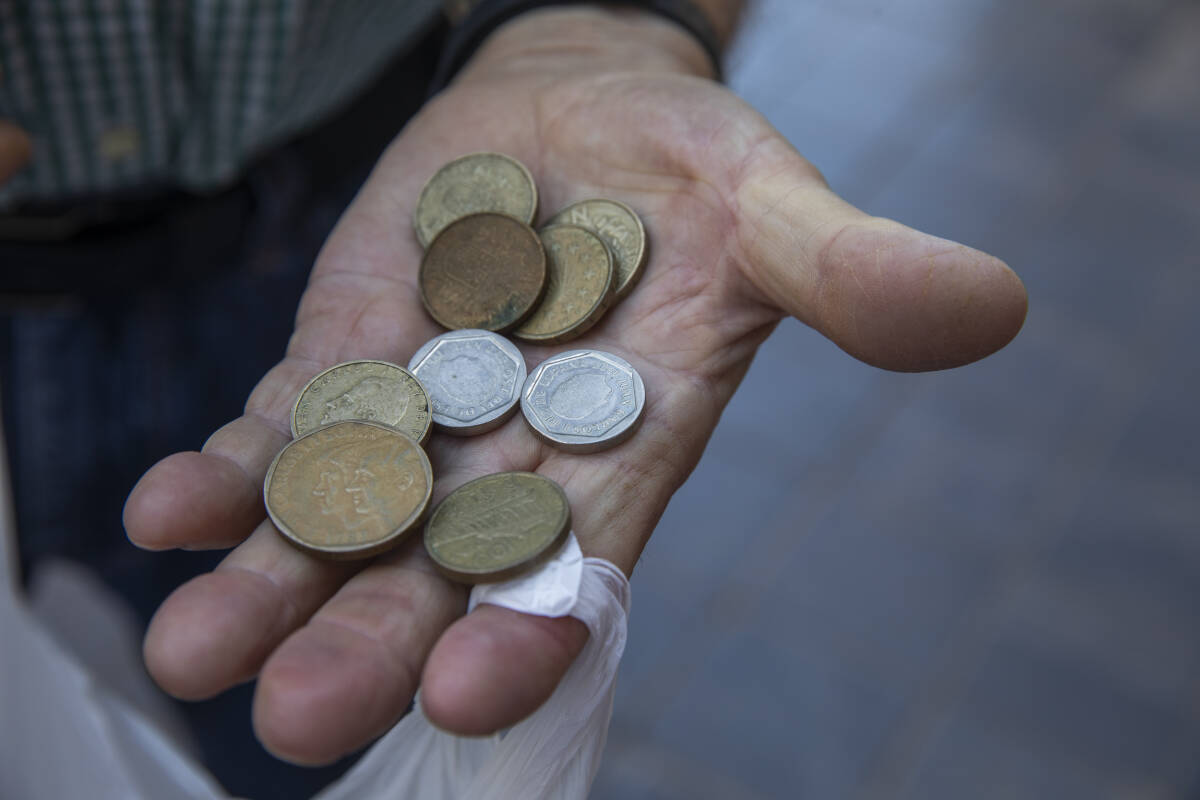 Un hombre de la cola muestra las pesetas. Foto: EVA MÁÑEZ